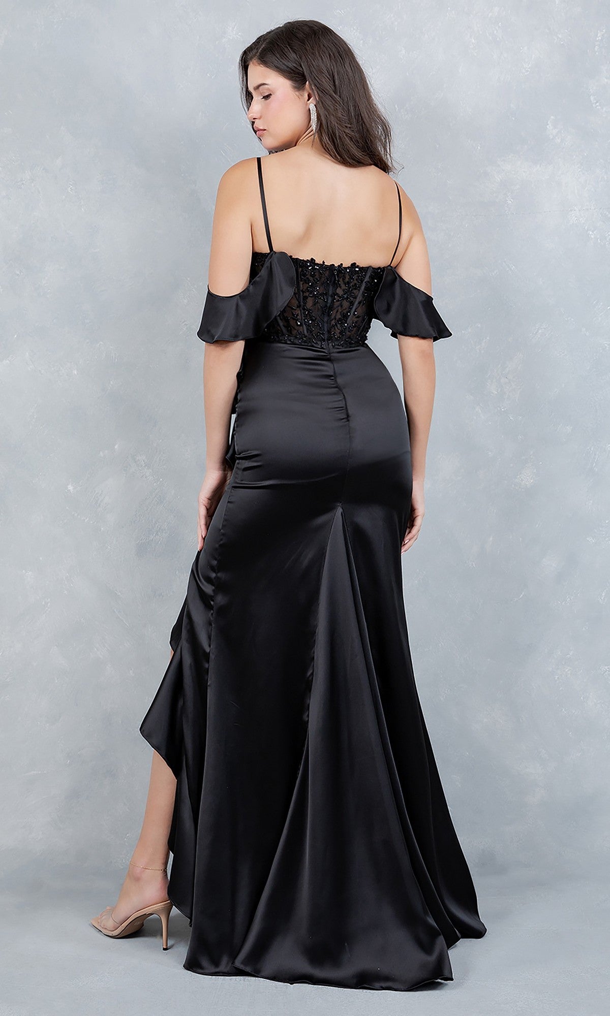 A woman stands with her back to the camera in the Cinderella Couture 8461J, a long black satin prom dress with thin straps, an off-shoulder design, and an embroidered floral corset bodice.